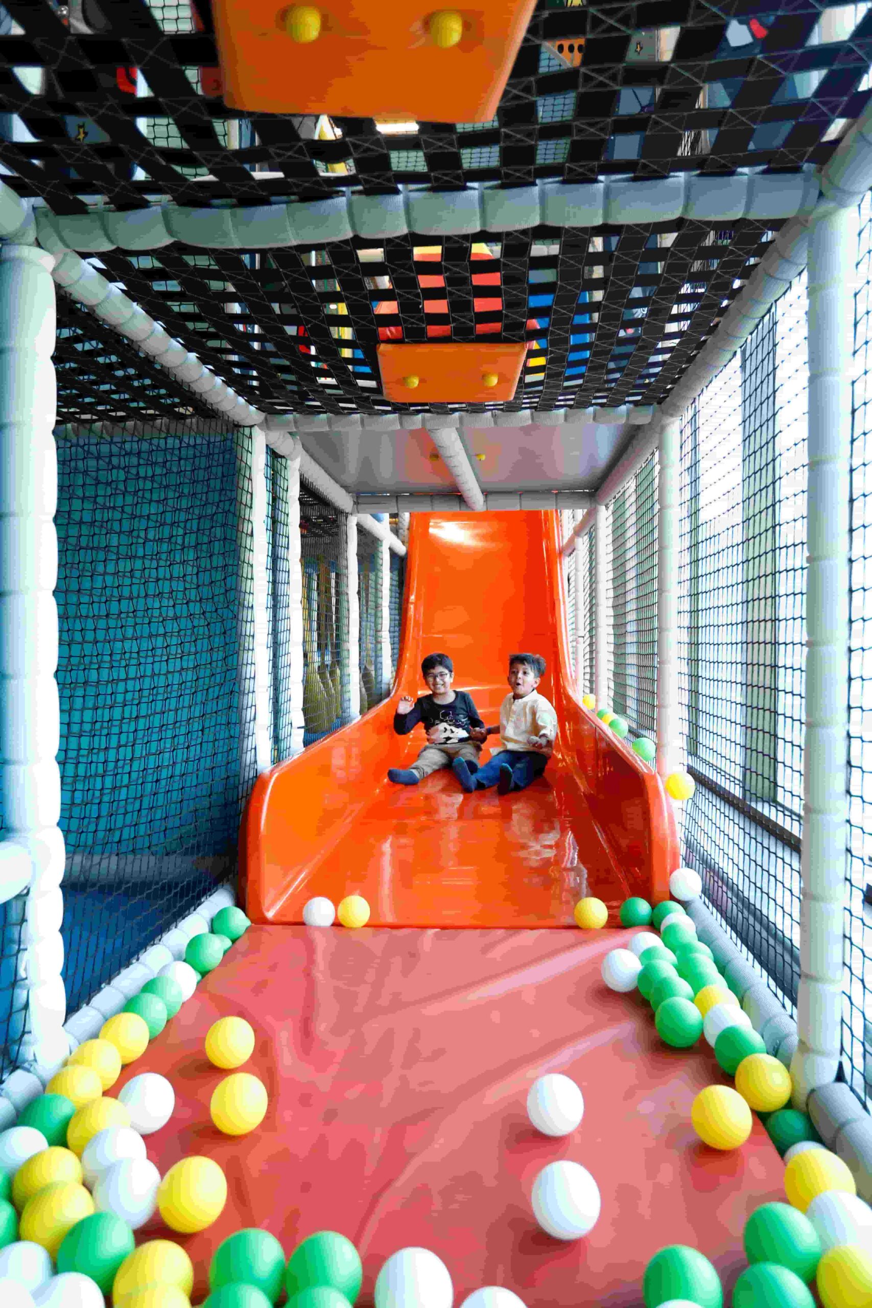 Children on the real orange Tingaland drop slide