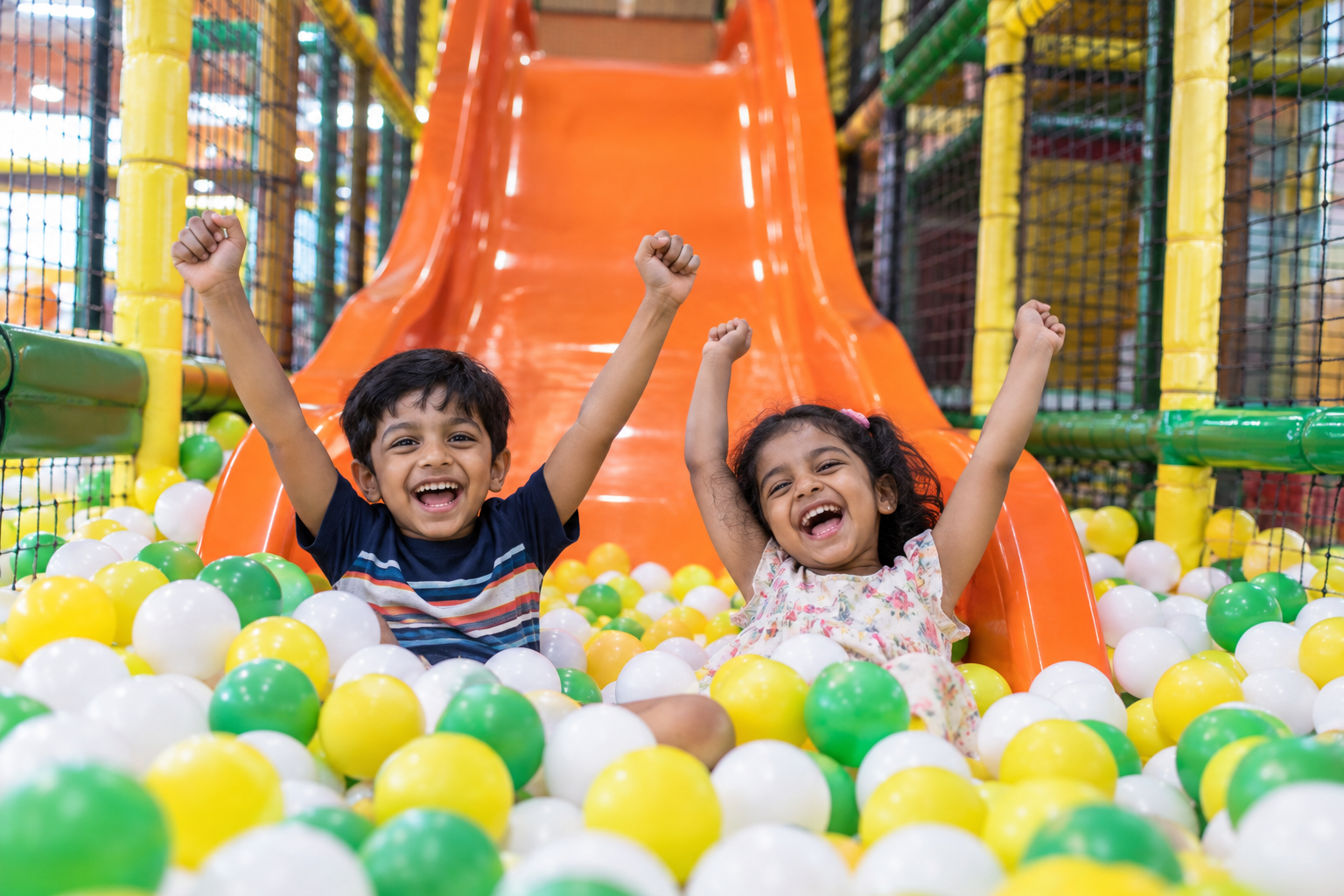 Children celebrating together in the soft ball pit