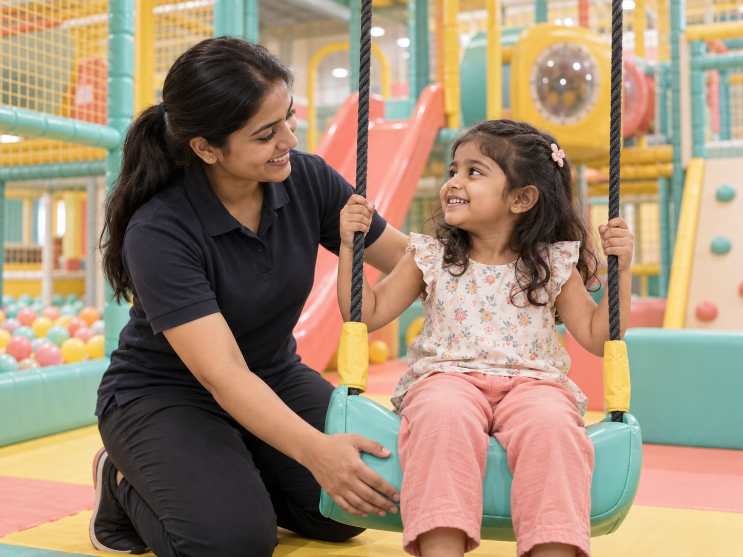 Play attendant supporting a child on the swing